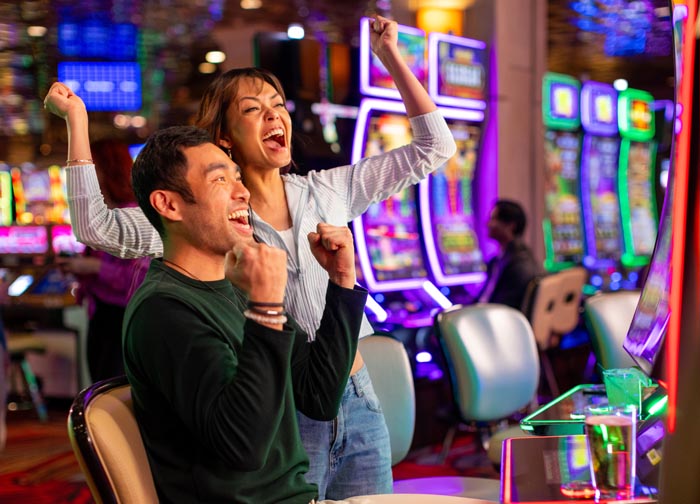 Couple Play Slots at Atlantis Casino in Reno, Nevada.