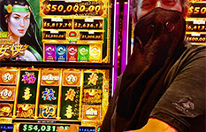 Jackpot Winner Elliot G sitting at a slot machine